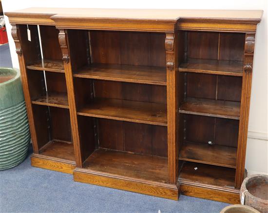 A late Victorian oak break front open bookcase W.153cm